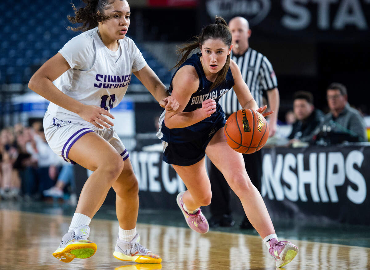 Gonzaga Prep guard Lucy Lynn (10) drives down the court with the ball as Sumner guard Olivia Collins (10) defends during an opening round game at the WIAA state basketball tournament in the Tacoma Dome in Tacoma, Washington, on Wednesday, March 1, 2023.