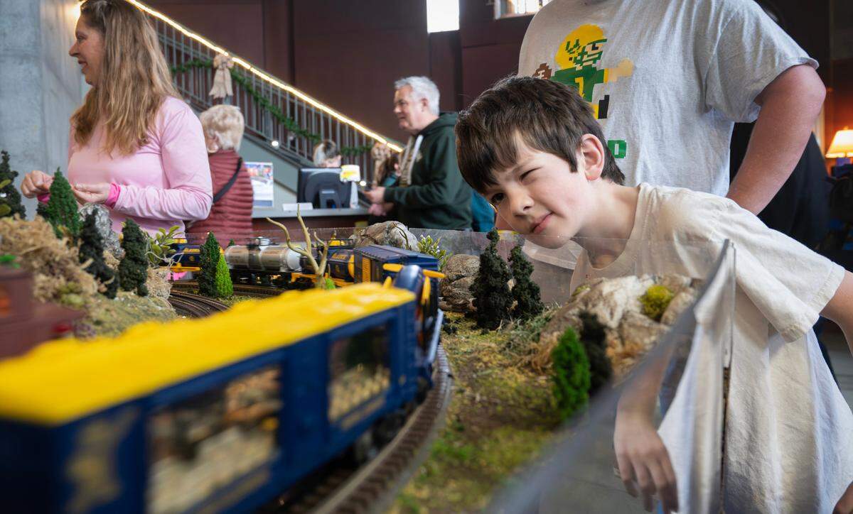 Barrett Odin, 7, of Vancouver, Washington, gets a close-up look at a passing train during the 28th Annual Model Train Festival at the Washington State History Museum in Tacoma, Washington, on Friday, Dec. 27, 2024. Barrett planned out the trip with his father, Geoff Odin, to travel to the festival by Amtrak and the Tacoma Link Light Rail. The Model Train Festival continues through January 1.