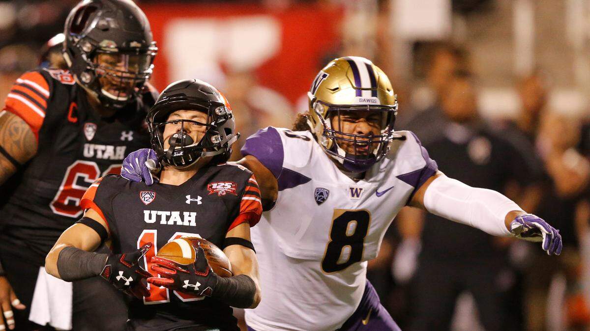 Washington linebacker Benning Potoa’e (8) tackles Utah wide receiver Britain Covey, left, in the first half during an NCAA college football game Saturday, Sept. 15, 2018, in Salt Lake City. (AP Photo/Rick Bowmer)