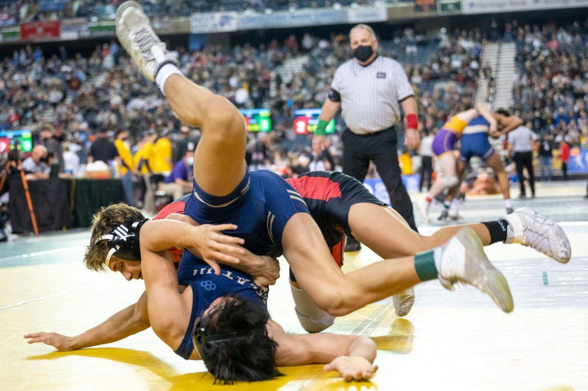Decatur’s Collin Jack gets flipped over by Sunnyside’s Christopher Villanueva during their 138-pound 4A semifinal match at Mat Classic XXXIII on Saturday, Feb. 19, 2022, at the Tacoma Dome in Tacoma, Wash. Villanueva won by decision, 6-5.