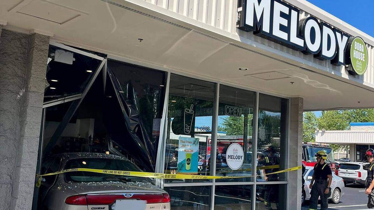 A gold sedan comes to a rest after crashing into the Melody Boba House in Puyallup. It trapped a customer in the store until bystanders were able to free her from the wreckage.