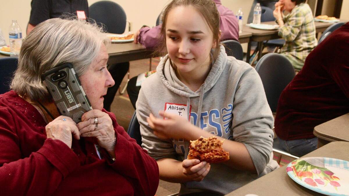 Gig Harbor High sophomore Allison Townsend helps Sonya Becker of Peninsula Independent Retirement Living understand the workings of voicemail on her iPhone.