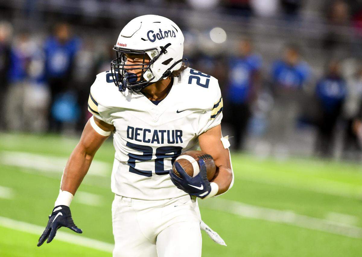 Decatur’s Nehemiah Washington (28) carries the ball against the Federal Way Eagles during the first half of the game at Federal Way Memorial Stadium, Thursday, Oct. 26, 2023, in Federal Way, Wash.