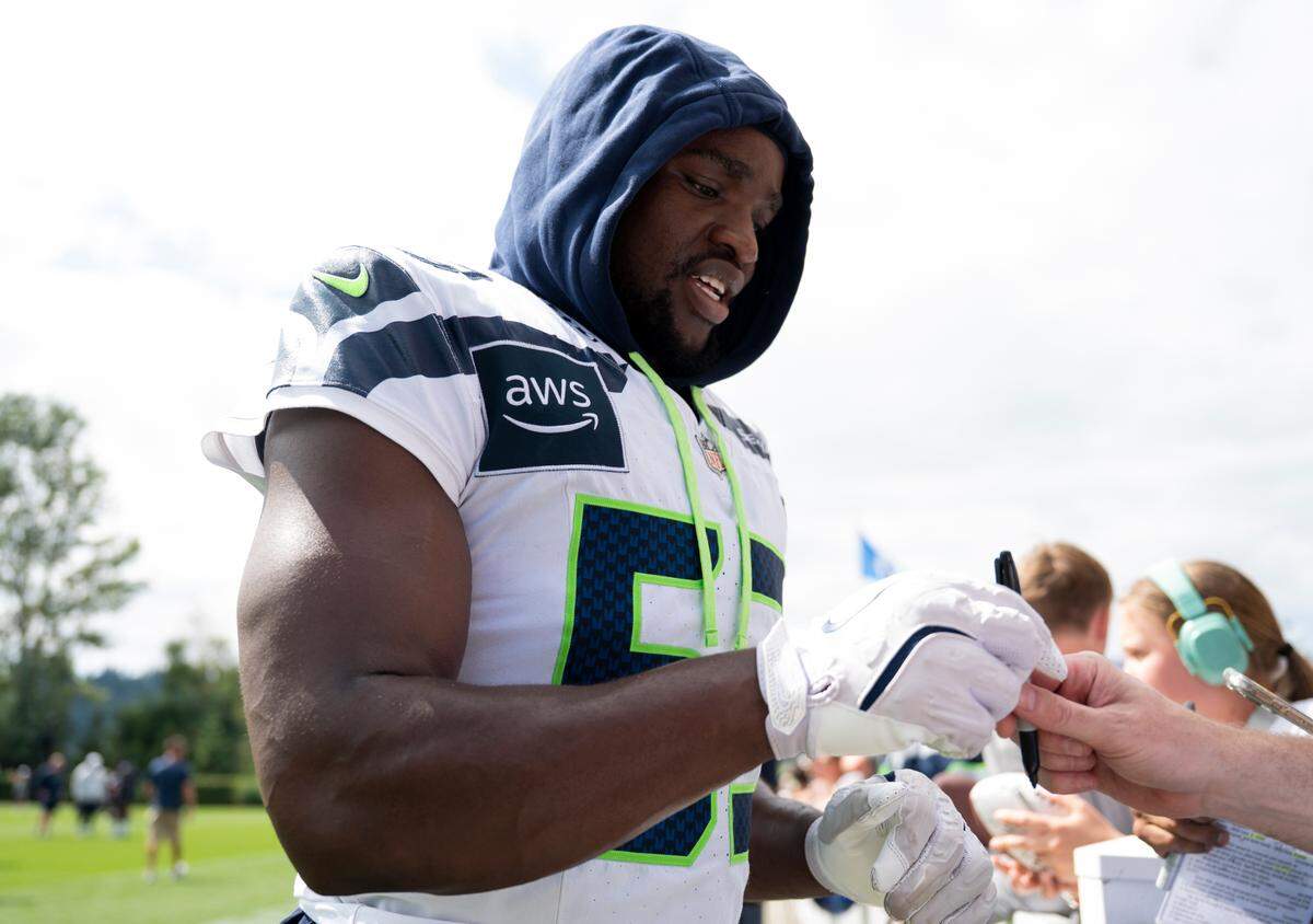 Seattle Seahawks linebacker Boye Mafe (53) signs autographs after training camp at Virginia Mason Athletic Center on Friday, July 25, 2025, in Renton.