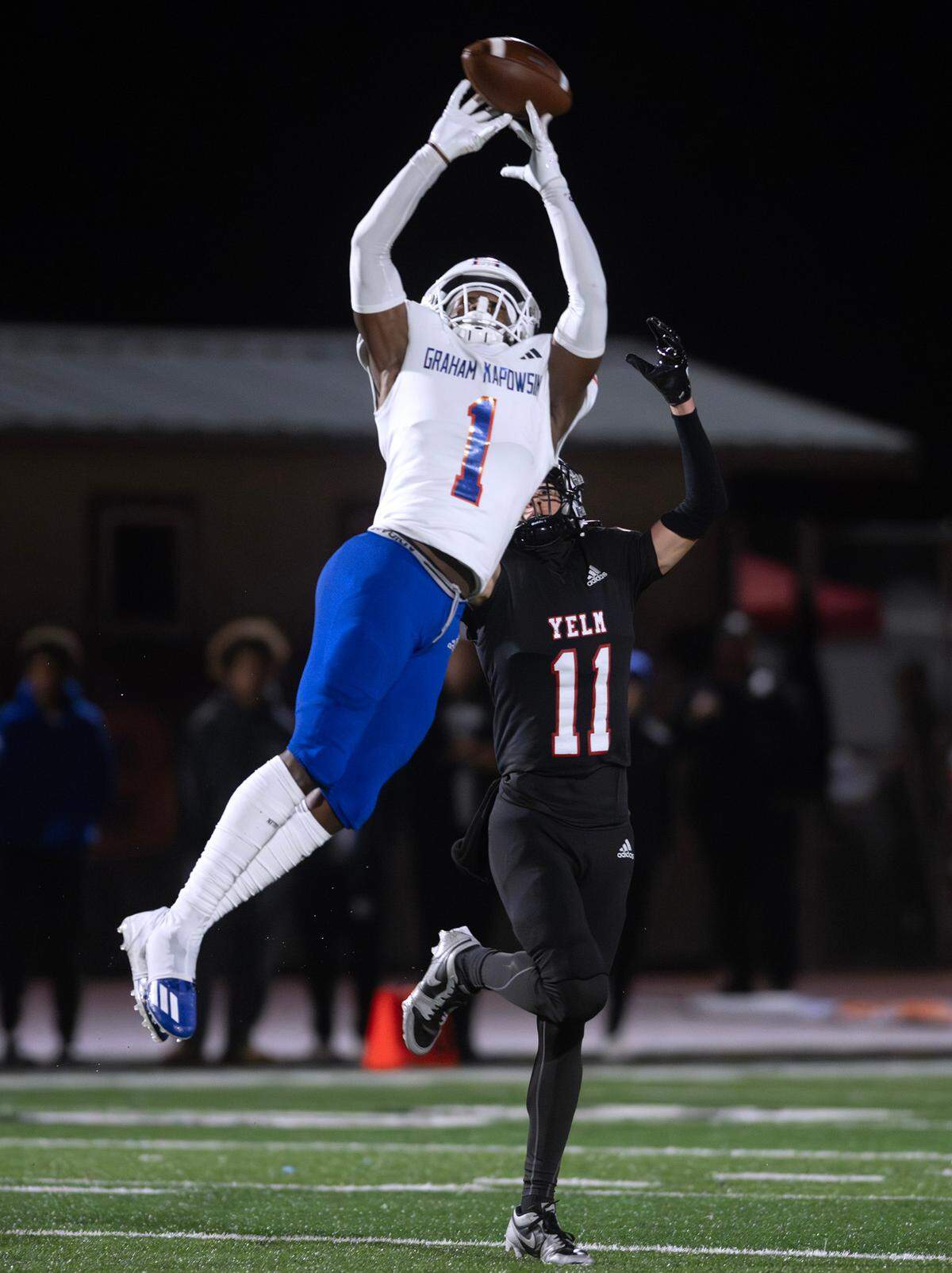 Graham Kapowsin wide receiver Khristian Norris stretches for a pass over Yelm defensive back Jay Sumich during Friday night’s football game at Yelm High School in Yelm, Washington, on Oct. 4, 2024.