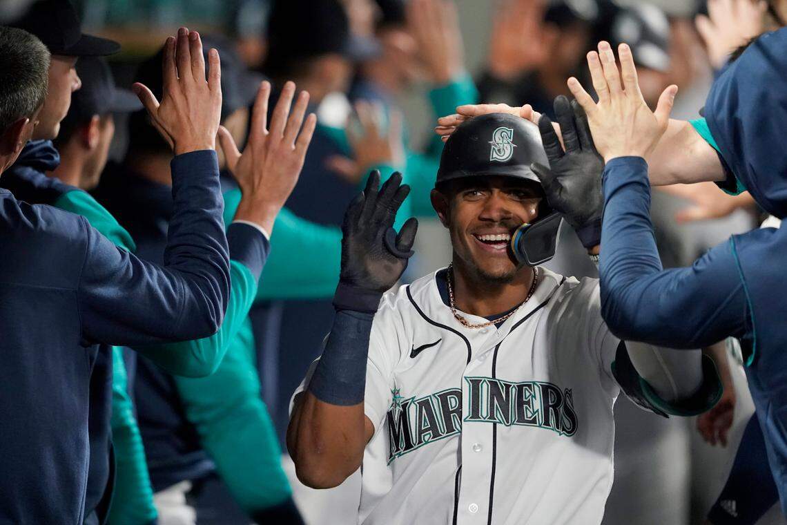 Seattle Mariners’ Julio Rodriguez is congratulated in the dugout after hitting a two-run home run against the Oakland Athletics during the fifth inning of a baseball game Tuesday, May 24, 2022, in Seattle. (AP Photo/Ted S. Warren)