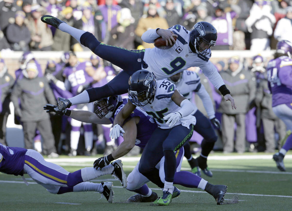 Seattle Seahawks punter Jon Ryan (9) jumps over Minnesota Vikings linebacker Casey Matthews (59) as he runs the ball during the first half of an NFL wild-card football game against the Minnesota Vikings, Sunday, Jan. 10, 2016, in Minneapolis. (AP Photo/Nam Y. Huh)