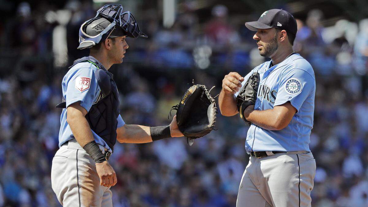 Seattle Mariners starting pitcher Nabil Crismatt, right, and catcher Austin Nola meet on the mound for a moment after Crismatt hit Chicago Cubs’ Kris Bryant with a pitch in the third inning of a spring training baseball game Tuesday, March 19, 2019, in Mesa, Ariz. (AP Photo/Elaine Thompson)