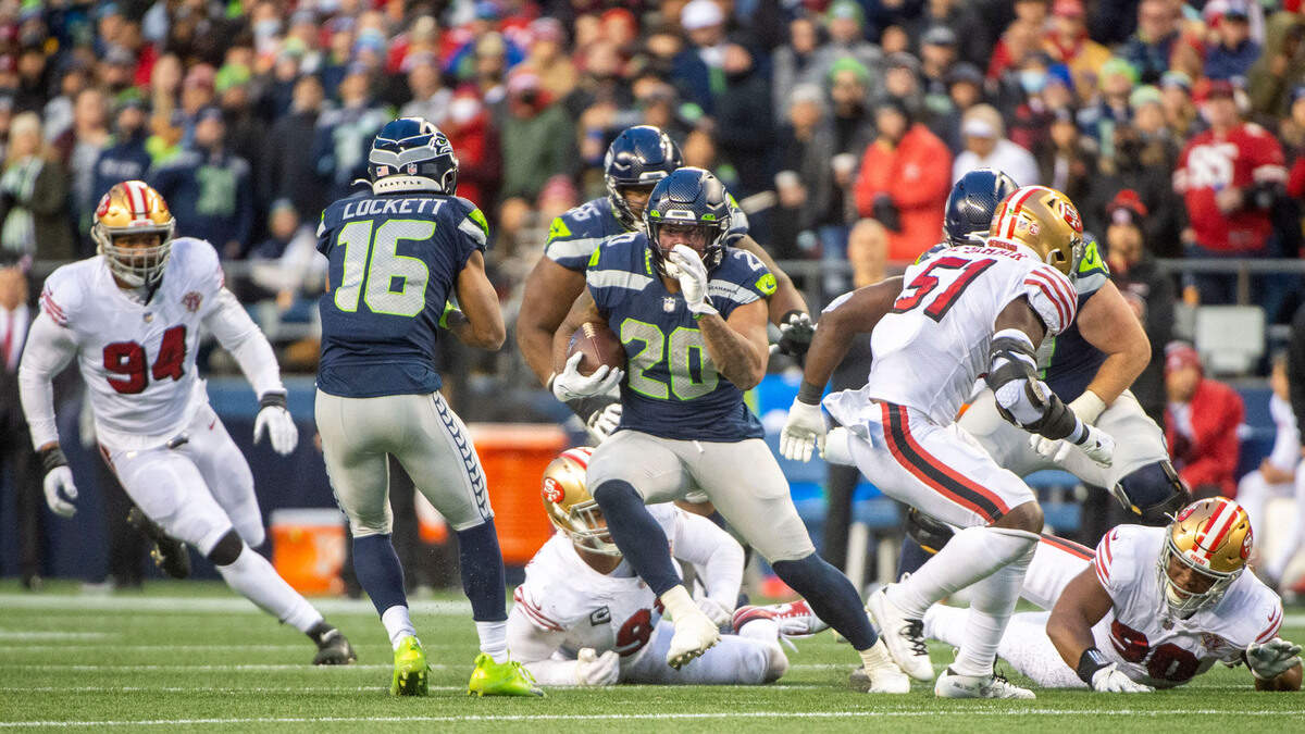Seattle Seahawks running back Rashaad Penny (20) breaks through the San Francisco 49ers defense after catching a screen pass in the fourth quarter of an NFL game on Sunday at Lumen Field in Seattle.