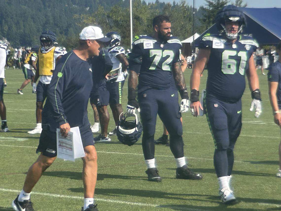 Run-game coordinator Rick Dennison (left), right tackle Abe Lucas (72) and center Jalen Sundell (61) at practice in Seattle Seahawks NFL training camp July 31, 2025, at the Virginia Mason Athletic Center in Renton.