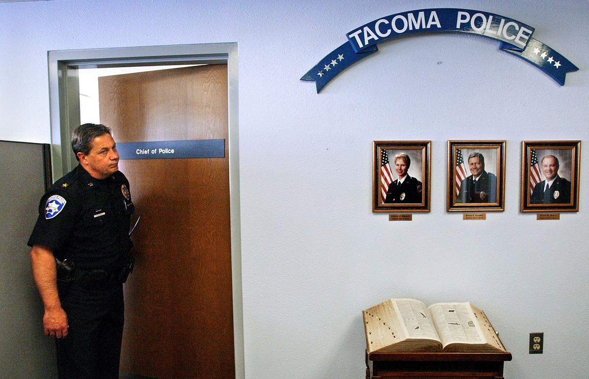 Assistant Tacoma police chief Don Ramsdell steps out of acting chief Catherine Woodard’s office where staff held a closed door meeting following a press conference in April 2003. Above the photos of Woodard, Ramsdell and assistant chief Richard McCrea is a nail hole where former chief David Brame’s portrait recently hung.