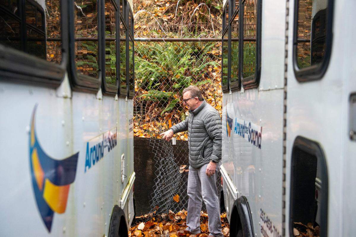 On Friday, Steve Hutchins, the CEO of Around the Sound — a medical transportation company, shows where people have cut through his fence while attempting to steal pieces of equipment from his property in the 2200 block of South Tacoma Way. Hutchins has been dealing with people breaking into his parking lot and stealing catalytic converters from his fleet of vans and buses. He would like the option of adding an electric fence to the property as a deterrent. The Tacoma City Council is looking into where electric fences should be allowed after hearing complaints from multiple businesses.