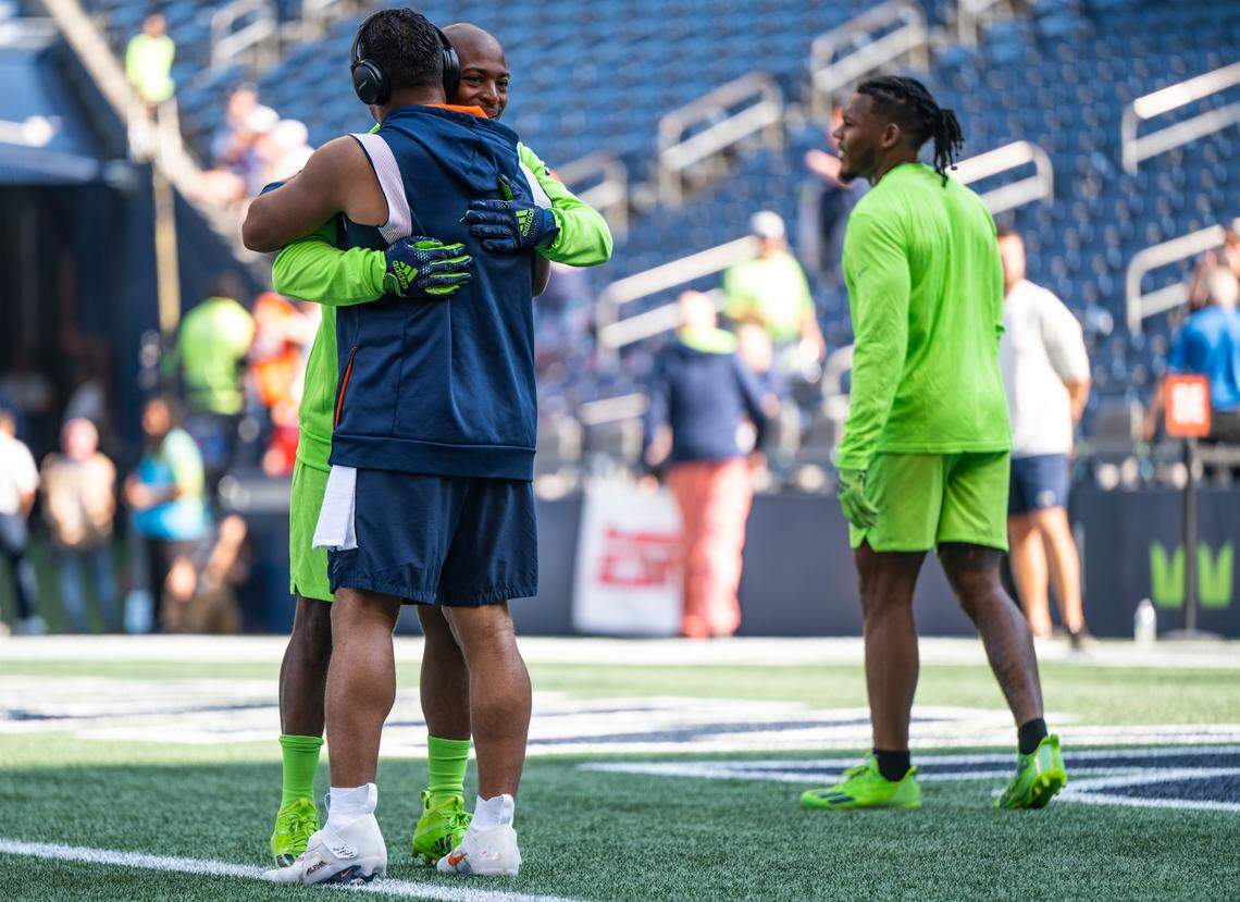Seattle Seahawks wide receiver Tyler Lockett (16) hugs former Seattle Seahawks quarterback Russell Wilson who is now a quarterback for the Denver Broncos before the start of an NFL game on Monday, Sept. 12, 2022, at Lumen Field in Seattle.
