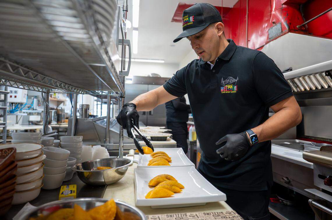 Chef German Espitia plates chicken and beef empanadas during the grand opening on July 10. The menu at Welcome Restaurant is an homage to the blending of cultures, with American, Mexican and Colombian dishes — often with flavors and ingredients from more than one cuisine.