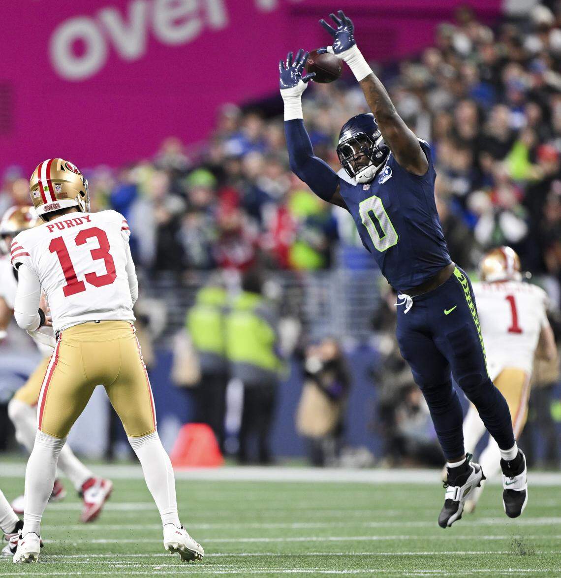 Seattle Seahawks defensive end DeMarcus Lawrence (0) jumps up as San Francisco 49ers quarterback Brock Purdy (13) throws during the first quarter of the NFC Divisional Round game at Lumen Field, on Saturday, Jan. 17, 2026, in Seattle.