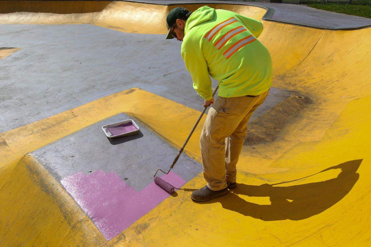 Todd Baginski, parks groundskeeper for the city of Sumner, paints over graffiti at the skate park in the Daffodil Valley Sports Complex on Wednesday, March 30.