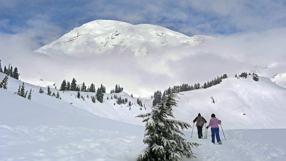 The mountain peeks out for snowshoers above Paradise on Feb. 7, 2010, in Mount Rainier National Park. Peter Haley / Staff photographer