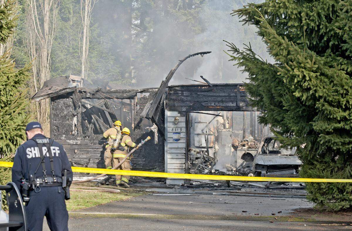 In February 2012, a Pierce County Sheriff’s deputy and Graham Firefighters work around the smoldering remains of the house near Fredrickson where Josh Powell killed his sons Charlie, 7, and Braden, 5 before setting the house on fire and killing himself.