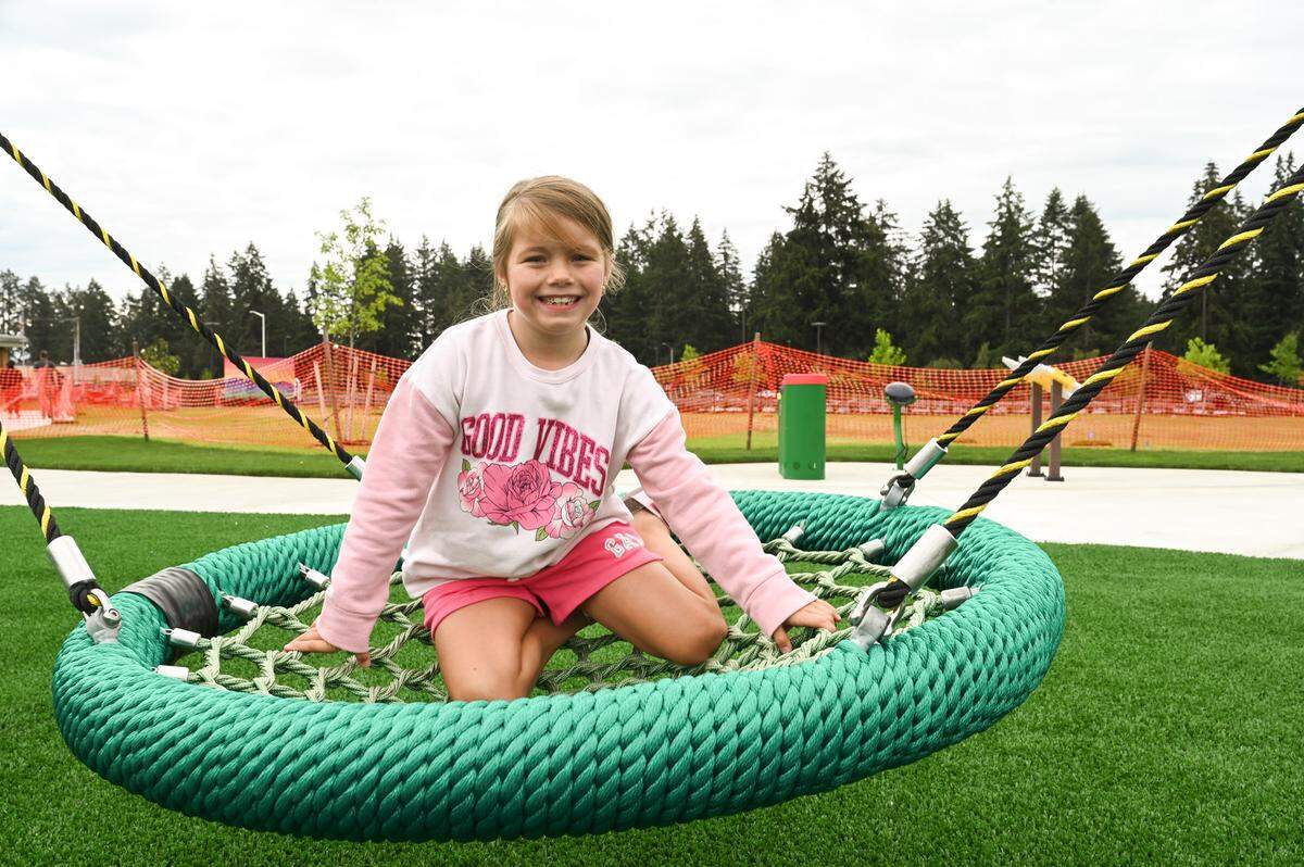 Autumn Barrow, 7 of Spanaway, flashes a smile as she tries out a swing at the newly built playground at Sprinker Recreation Center on Friday, Aug. 16, 2024 in Spanaway.
