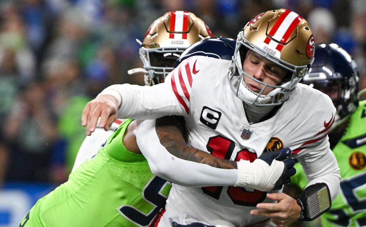 Seattle Seahawks defensive end Leonard Williams (99) hits Seattle Seahawks wide receiver Cody Thompson (13) as he throws during the first quarter of the game at Lumen Field, Thursday, Nov. 23, 2023, in Seattle, Wash.