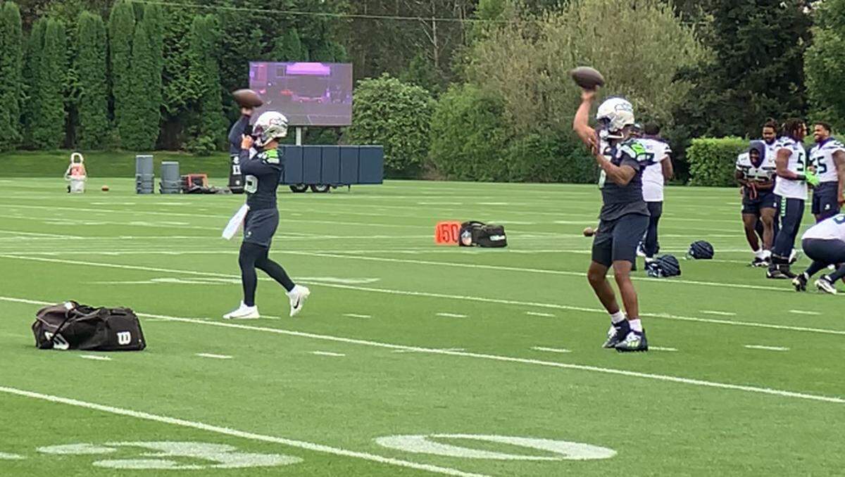 New third quarterback Jaren Hall (left) and starter Geno Smith (right) throwing before the Seahawks practice Sept. 2, 2024. They are wearing the silver helmets Seattle was to wear with 1990s throwback uniforms for its season opener Sept. 8, 2024, against the Denver Broncos at Lumen Field.