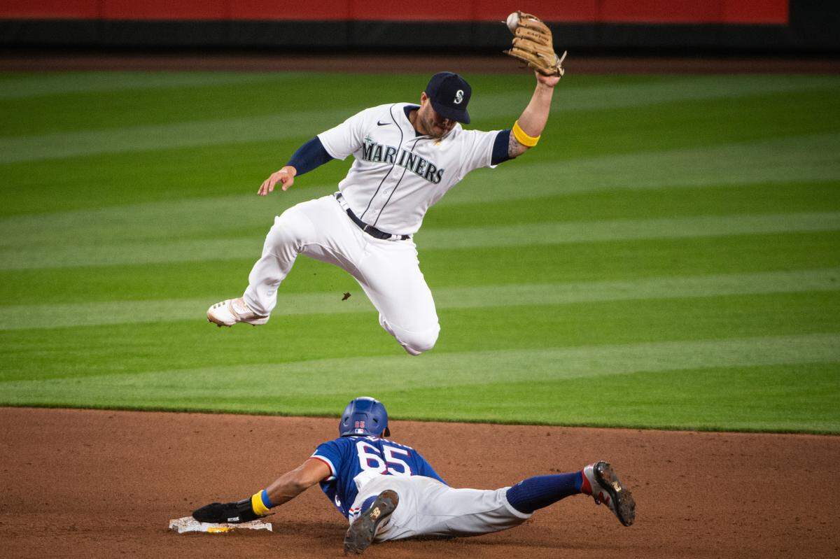 Seattle Mariners third baseman Ty France (23) goes airborne for a throw during a steal attempt by Texas Rangers center fielder Leody Taveras (65). The Seattle Mariners played the Texas Rangers in a Major League Baseball game at T-Mobile Park in Seattle, Wash., on Saturday, Sept. 5, 2020.