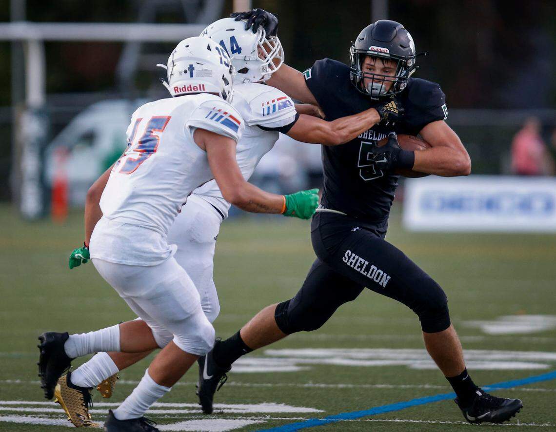 Sheldon’s Patrick Herbert fights off Graham-Kapowsin defender Seth Olmos (14) during the first quarter on Friday, Aug. 31, 2018 at Sheldon High School.