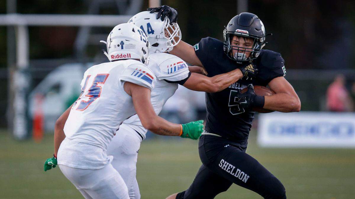 Sheldon’s Patrick Hebert fights off Graham-Kapowsin defender Seth Olmos (14) during the first quarter on Friday, Aug. 31, 2018 at Sheldon High School.