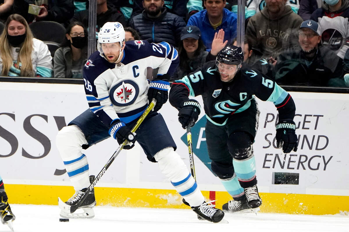 Winnipeg Jets’ Blake Wheeler, left, skates ahead of Seattle Kraken’s Mark Giordano in the first period of an NHL hockey game Thursday, Dec. 9, 2021, in Seattle. (AP Photo/Elaine Thompson)