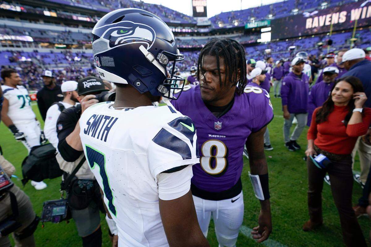 Baltimore Ravens quarterback Lamar Jackson (8) talks with Seattle Seahawks quarterback Geno Smith (7) after an NFL football game, Sunday, Nov. 5, 2023, in Baltimore. The Ravens won 37-3. (AP Photo/Alex Brandon)