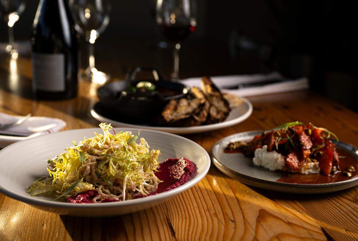 The Table in Tacoma is known for its thoughtful, seasonal dishes. The frisée with beet hummus (left) is one of the staff’s current favorites in part because “it doesn’t taste like winter,” said Bray.