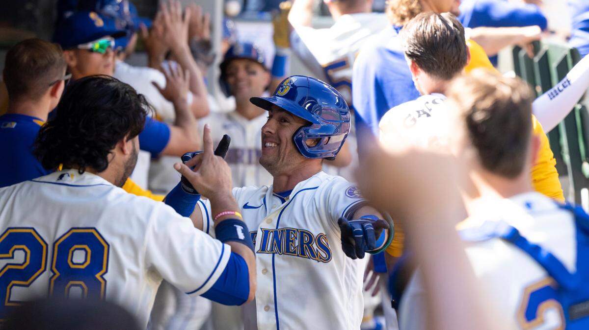 Seattle Mariners’ Dylan Moore is congratulated by teammates in the dugout after hitting a three-run home run off Cleveland Guardians starting pitcher Aaron Civale during the fifth inning of a baseball game, Sunday, Aug. 28, 2022, in Seattle. (AP Photo/Stephen Brashear)