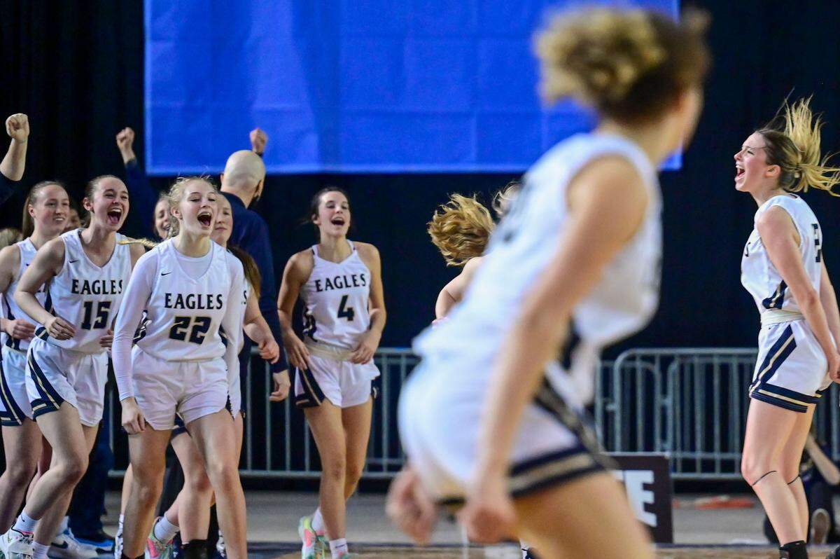 Arlington players celebrate after beating Snohomish, 50-47, in a Class 3A quarterfinal state tournament game on Thursday, March 3, 2022, at the Tacoma Dome, in Tacoma, Wash.