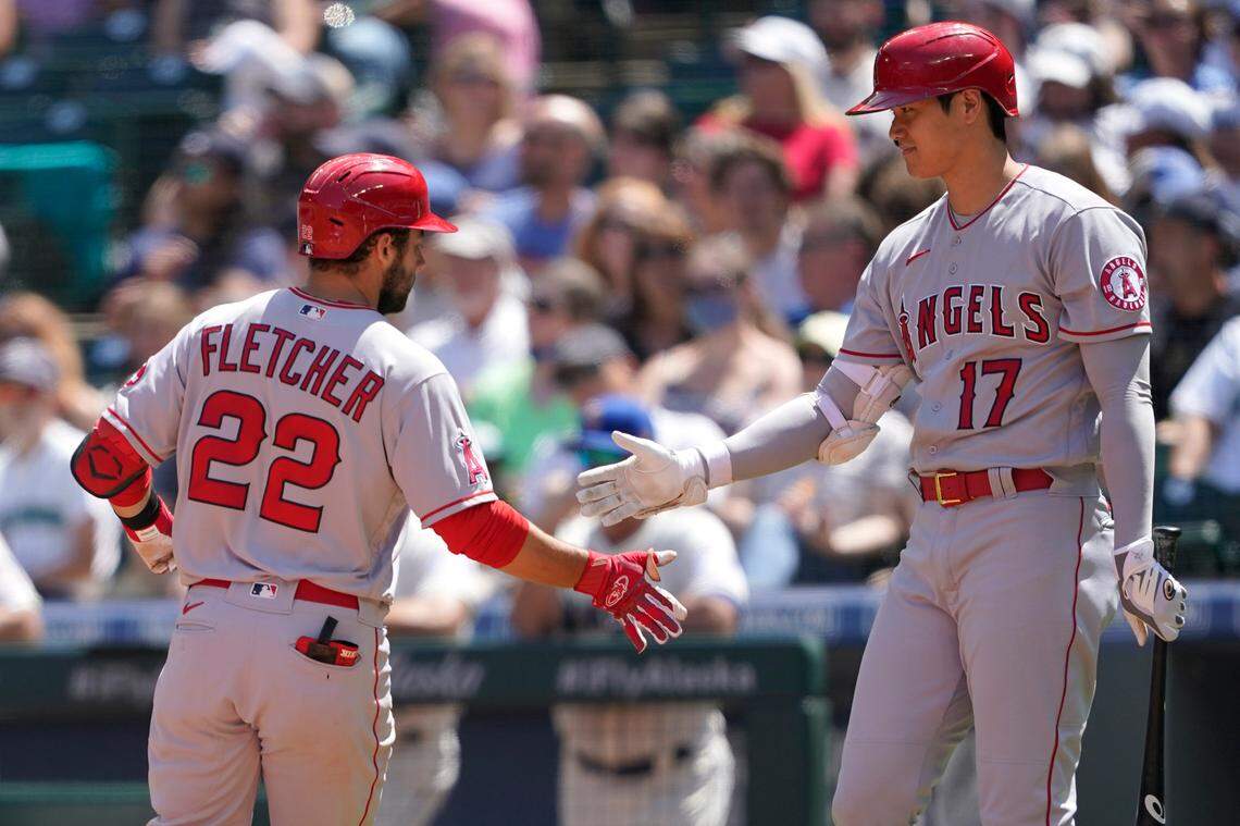 Los Angeles Angels’ David Fletcher (22) is greeted at the plate by Shohei Ohtani (17) after Fletcher hit a solo home run during the third inning of a baseball game against the Seattle Mariners, Sunday, July 11, 2021, in Seattle. (AP Photo/Ted S. Warren)