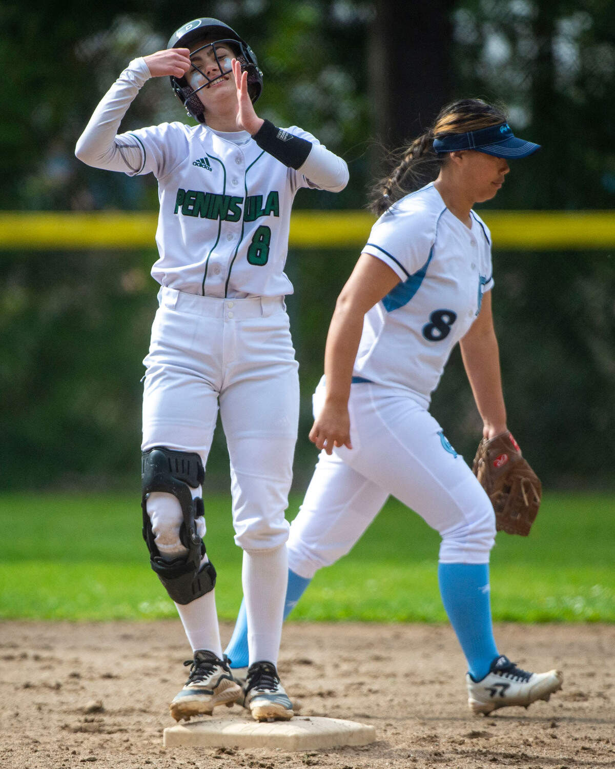 Peninsula’s Hailey Ruckle celebrates after hitting a double as Gig Harbor second baseman Audrey Allen walks away from the bag during the bottom of the third inning of a 3A South Sound Conference game on Wednesday, April 6, 2022, at Peninsula High School in Gig Harbor, Wash.