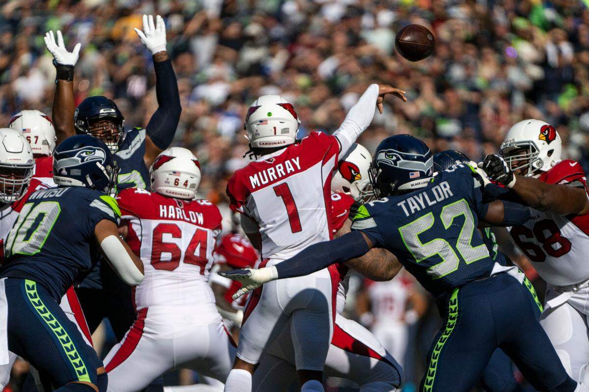 Arizona Cardinals quarterback Kyler Murray (1) attempts a pass through a crowded Seahawks defensive rush during the first quarter of an NFL game on Sunday, Oct. 16, 2022, at Lumen Field in Seattle.