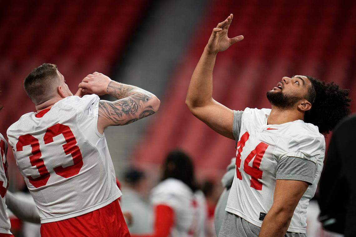 Ohio State Buckeyes defensive ends Jack Sawyer (33) and JT Tuimoloau (44) do a handshake during practice for the College Football Playoff against the Notre Dame Fighting Irish at the Mercedes-Benz Stadium in Atlanta on Jan. 18, 2025.