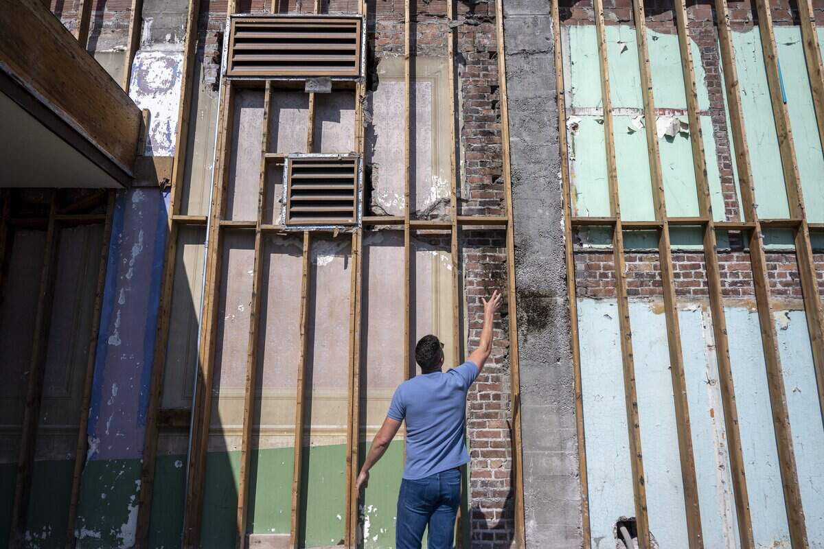 Dalton Arndt points out historic details uncovered at the former Bank of America building in downtown Sumner on Monday, July 13, 2026. These details, like the painted walls from the former theater in Sumner, will be preserved as the building undergoes construction.