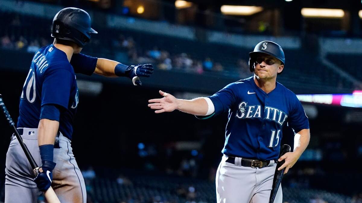 Seattle Mariners’ Kyle Seager (15) celebrates his run scored against the Arizona Diamondbacks with teammate Jarred Kelenic (10) during the 11th inning of a baseball game Sunday, Sept. 5, 2021, in Phoenix. (AP Photo/Ross D. Franklin)