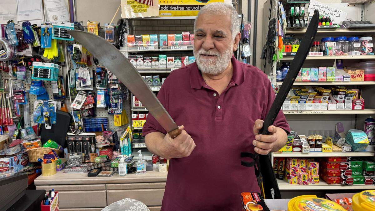 Naif Qatamin shows the machete that he used to scare off a would be robber on February 5 at his Hilltop convenience store. (Craig Sailor/The News Tribune)