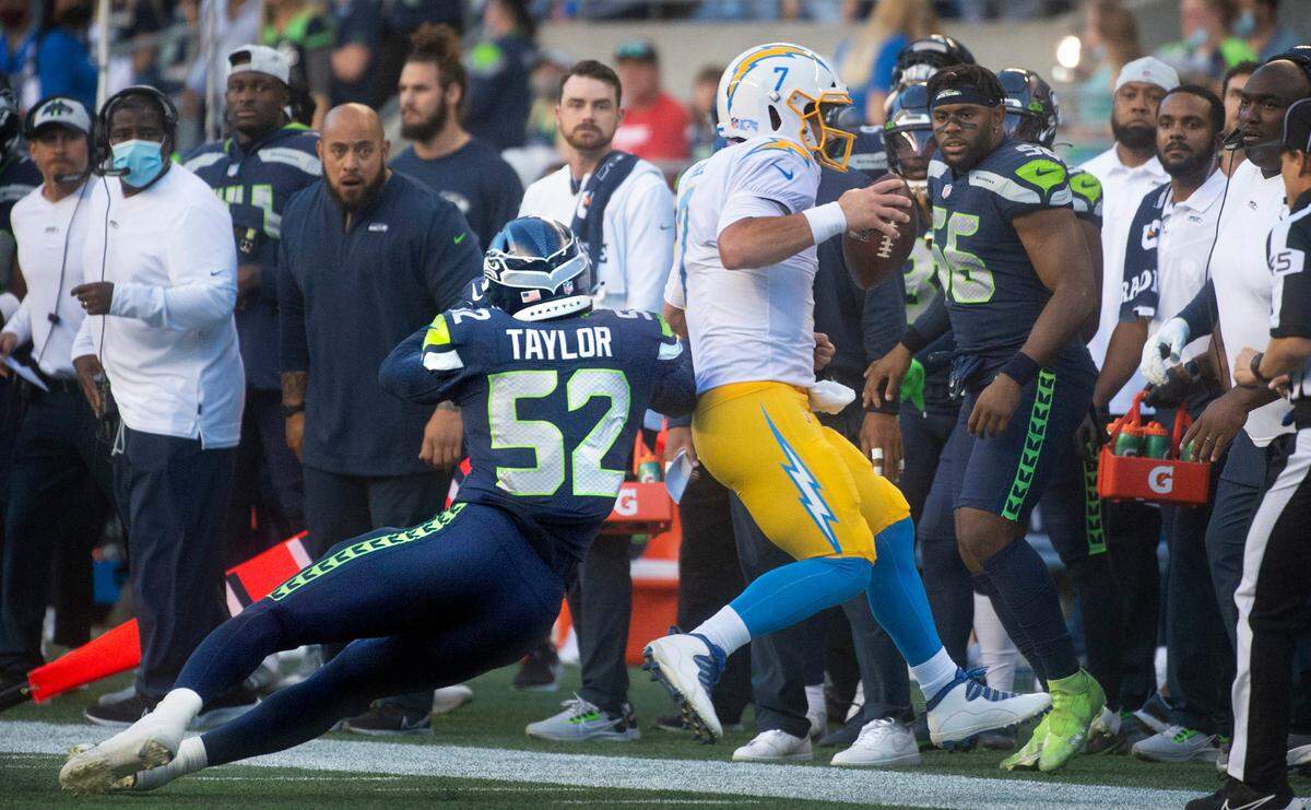 Seattle defensive end Darrell Taylor chase down Los Angeles quarterback Chase Daniel during Saturday night’s NFL preseason football game against the Los Angeles Chargers at Lumen Field in Seattle, Washington, on Aug. 28, 2021.