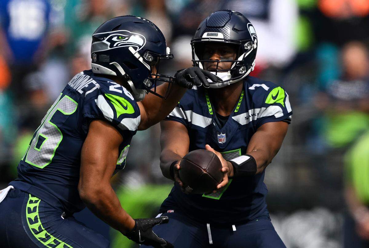 Seattle Seahawks quarterback Geno Smith (7) hands off the ball to running back Zach Charbonnet (26) during the first quarter of the game at Lumen Field, on Sunday, Sept. 22, 2024, in Seattle, Wash.
