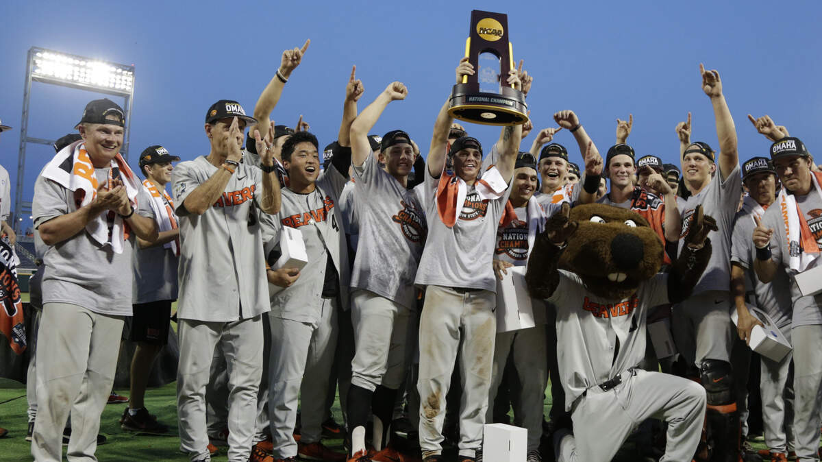 Oregon State players and coaches celebrate with their mascot and the trophy after they beat Arkansas 5-0 in Game 3 to win the NCAA College World Series baseball finals, Thursday, June 28, 2018, in Omaha, Neb. (AP Photo/Nati Harnik)