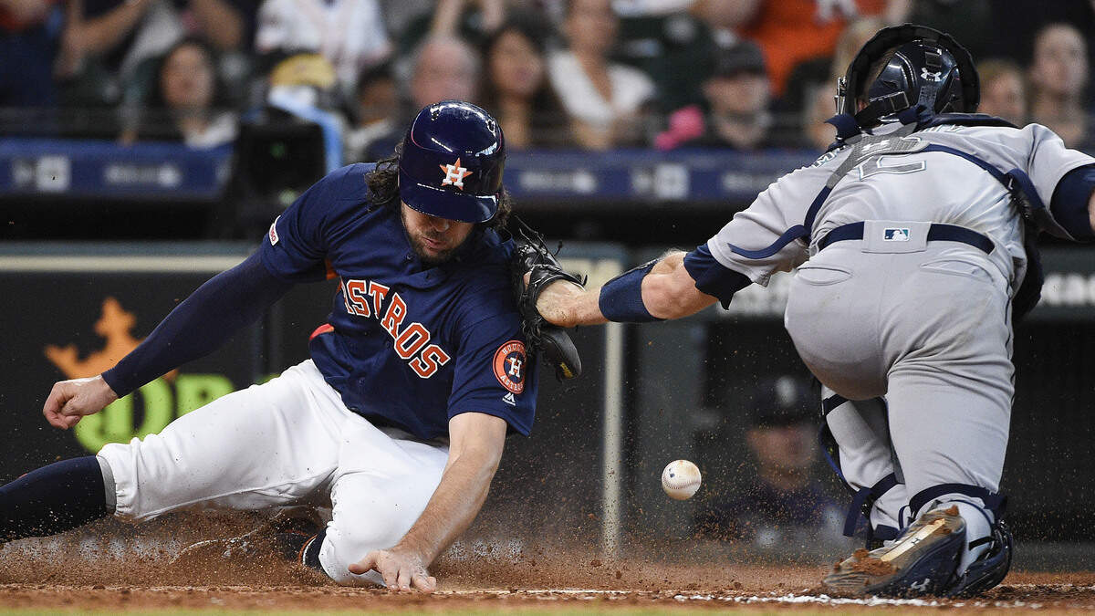 Houston Astros’ Jake Marisnick, left, slides safely past Seattle Mariners catcher Tom Murphy to score on Jose Altuve’s two-run single during the eighth inning of a baseball game, Sunday, June 30, 2019, in Houston.