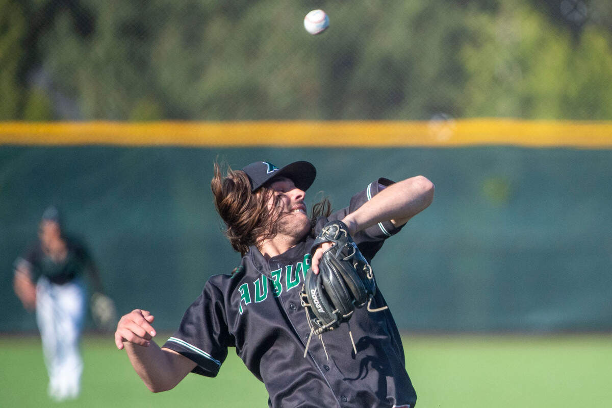 Auburn reliever Tanner Hanson attempts to field a ground ball up the middle during the bottom of the fifth inning of a State 3A playoff quarterfinal against Mercer Island on Saturday, May 21, 2022, at Auburn High School in Auburn, Wash.