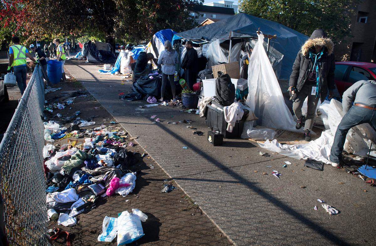 People pack up their belongings at the homeless encampment along South Yakima Street in Tacoma, Washington, on Tuesday, Sept. 21, 2021.
