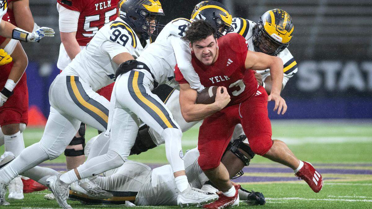 Yelm running back Brayden Platt loses his helmet as he runs against the Bellevue defense during Friday night’s 3A football state championship game at the University of Washington Stadium in Seattle, Washington, on Dec. 1, 2023. Platt was disqualified from the game after throwing a punch at one of the Bellevue players after the whistle.