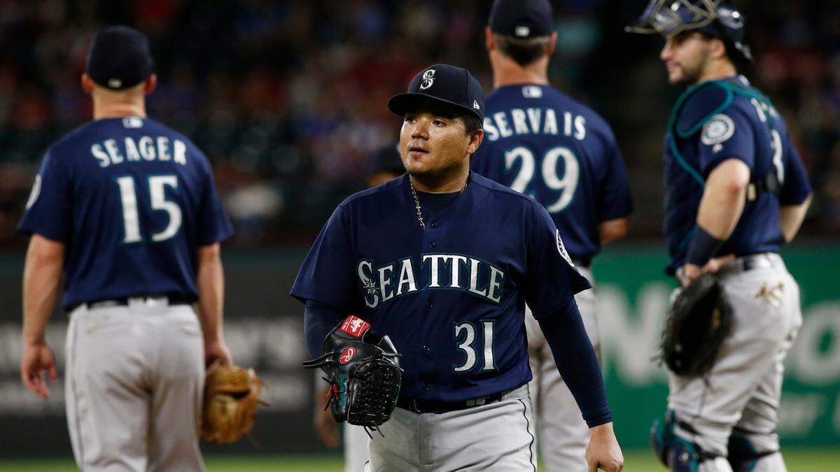 Seattle Mariners starting pitcher Erasmo Ramirez (31) leaves a baseball game against the Texas Rangers as third baseman Kyle Seager (15), manager Scott Servais and catcher Mike Zunino wait on the mound during the third inning of a baseball game Friday, Sept. 21, 2018, in Arlington, Texas. (AP Photo/Mike Stone)