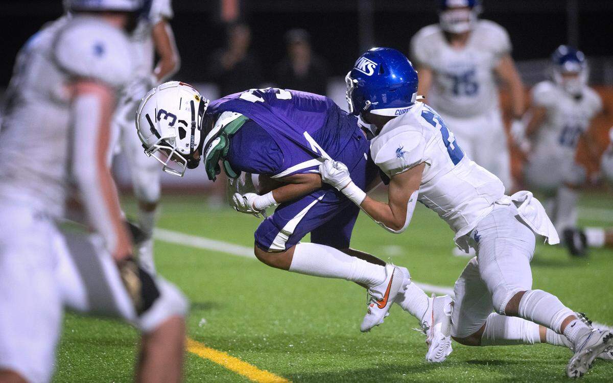 Sumner wide receiver Braylon Pope drags Curtis defensive back Jiwon Jang into the end zone for a touchdown reception during Friday night’s football game at Sunset Chevy Stadium in Sumner, Washington, on Sept. 8, 2023. Curtis won the game, 38-33.