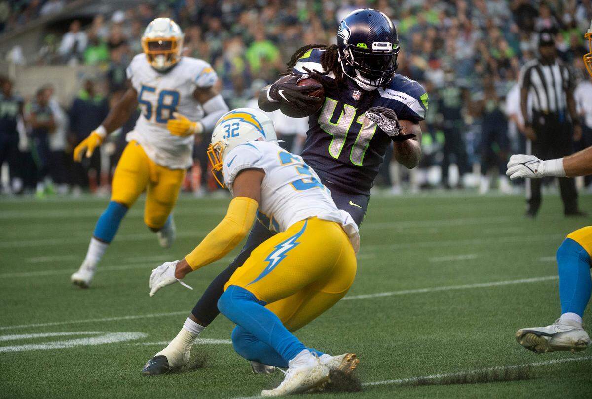 Seattle running back Alex Collings tries to evade Los Angeles safety Alohi Gilman during Saturday night’s NFL preseason football game against the Los Angeles Chargers at Lumen Field in Seattle, Washington, on Aug. 28, 2021.